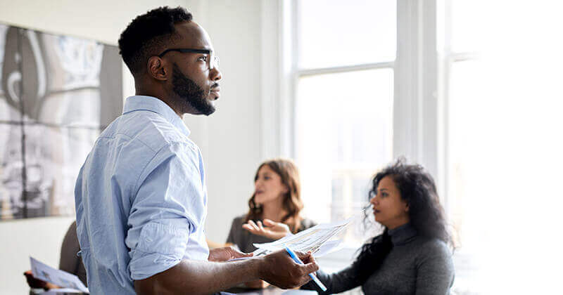 Holding documents colleagues discussing