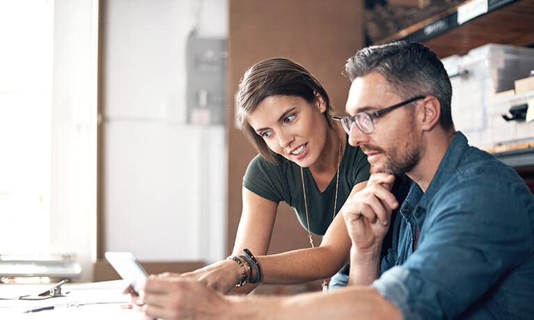 Man and woman looking at report on tablet