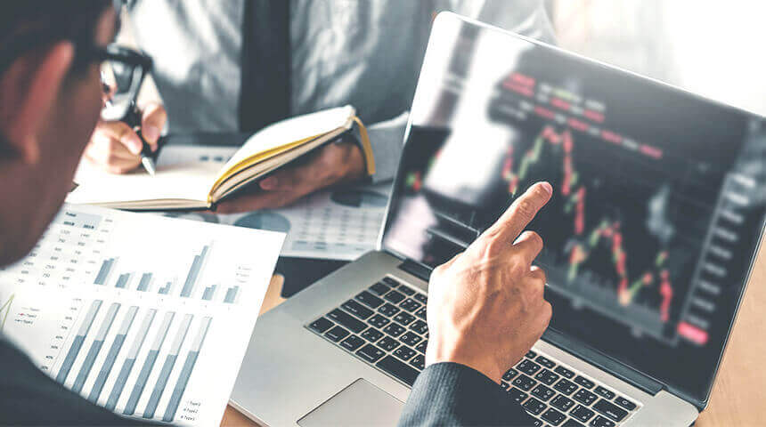 Man pointing at analytics on laptop screen