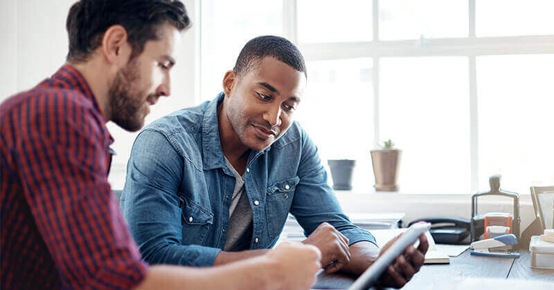 Men colleagues going over ideas tablet