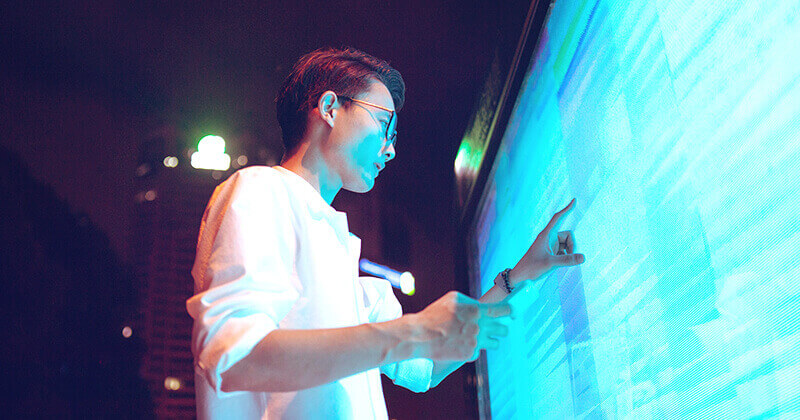 Man touching analytics on large screen