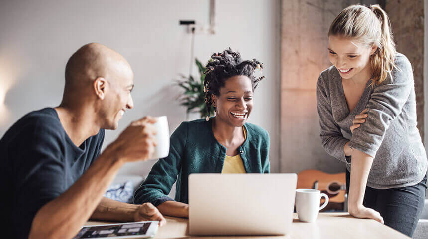 Smiling business people looking laptop