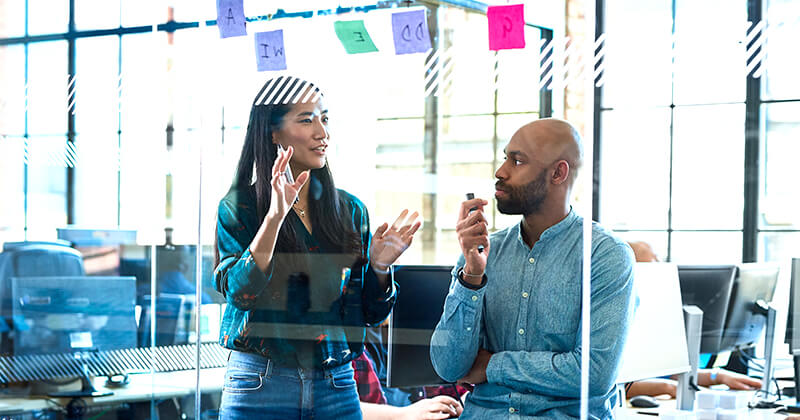 People discussing post it notes on board