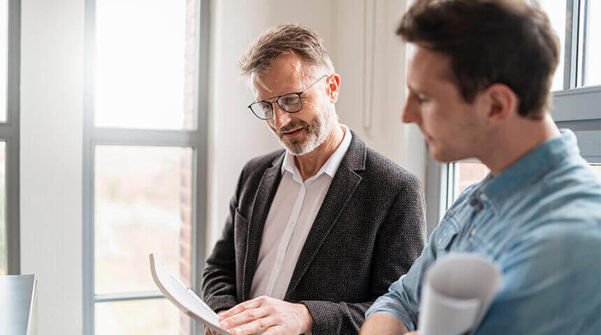 Two colleagues talking at window