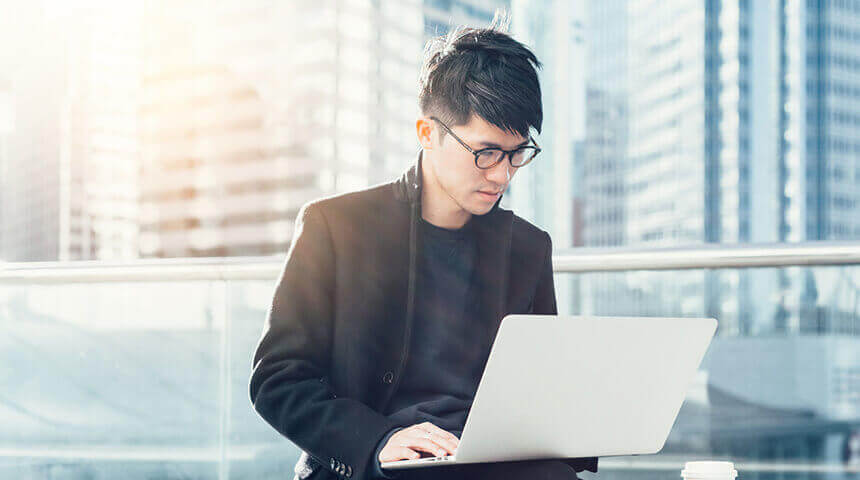 young businessman using laptop terrace