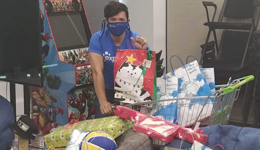 Felipe C. posing with a large amount of gifts ready to be donated