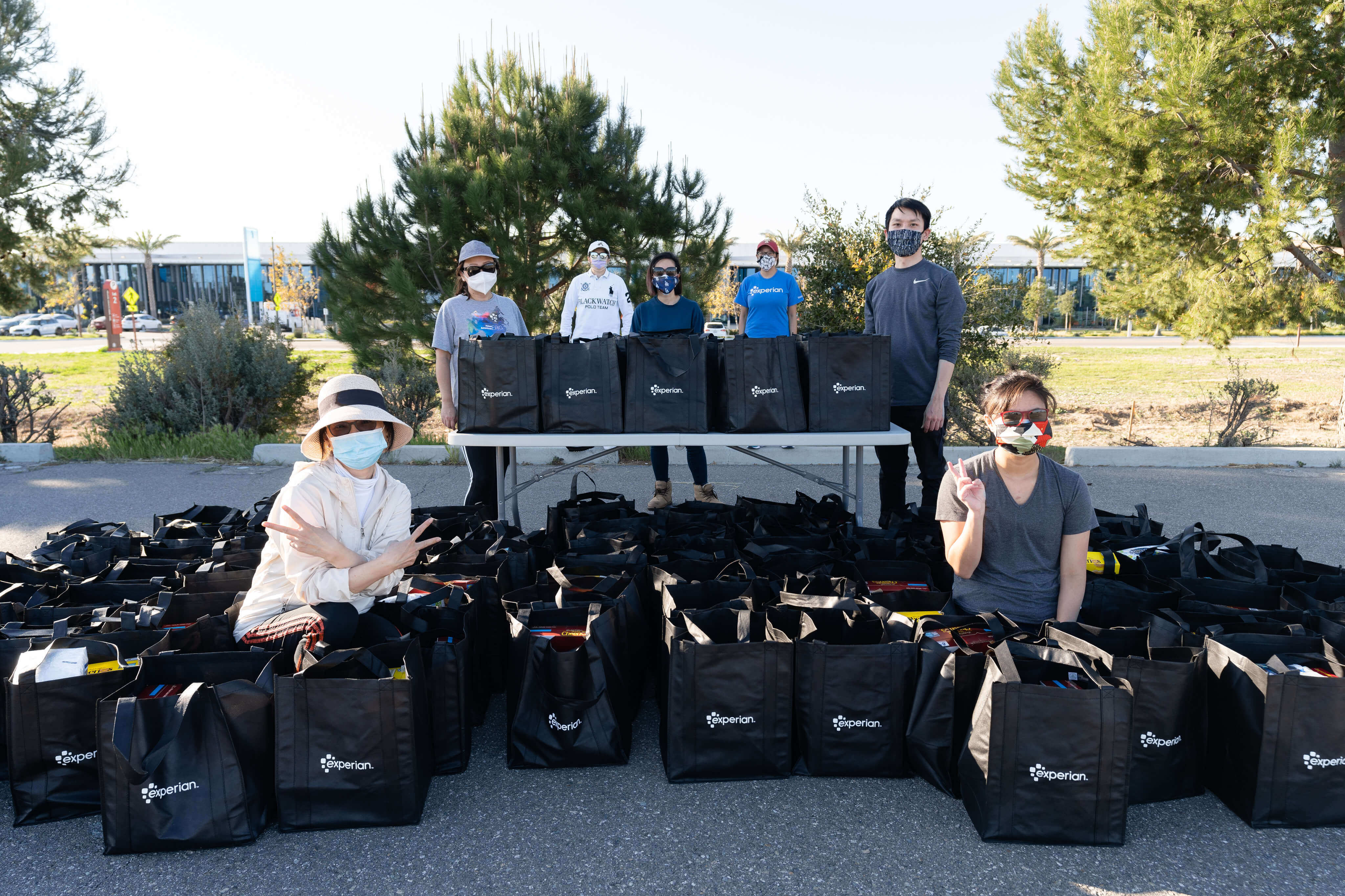 Group of Experian employees posing with hundreds of bags filled for a local non-profit