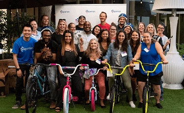 Group of Experia employees sitting on bicycles at a fundraising event 