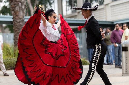Two traditional mariachi dancers dancing together during an Experian ERG event