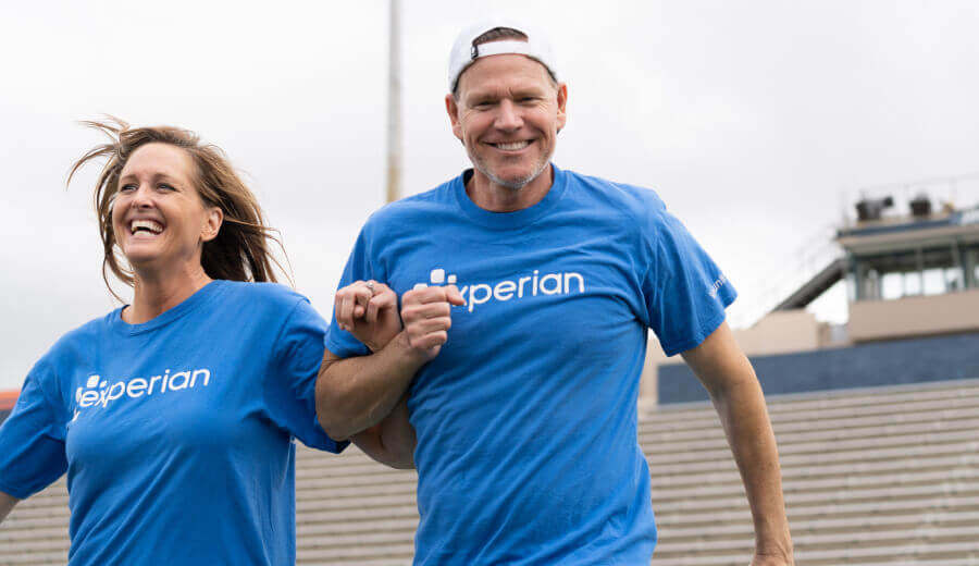 Two Experian employees wearing blue volunteer shirts exercising at an Experian event