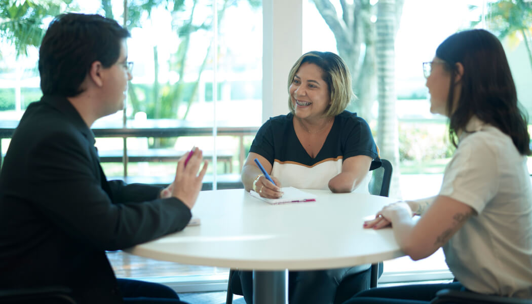 Experian employees talking with a female amputee around a white, circular table