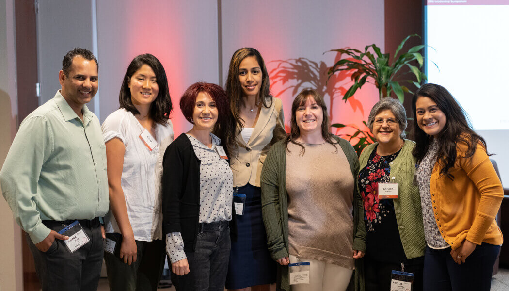 A group of diverse Experian employees posing for the camera at an event