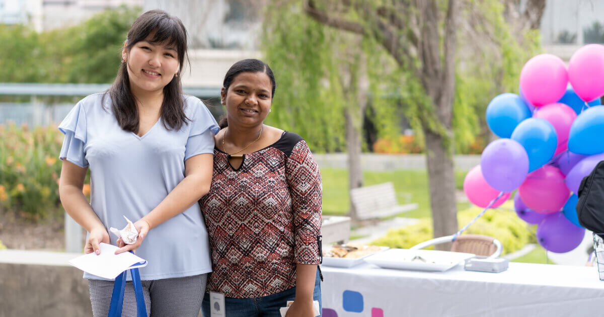 A picture of two women employees at a new hire fair at HQ