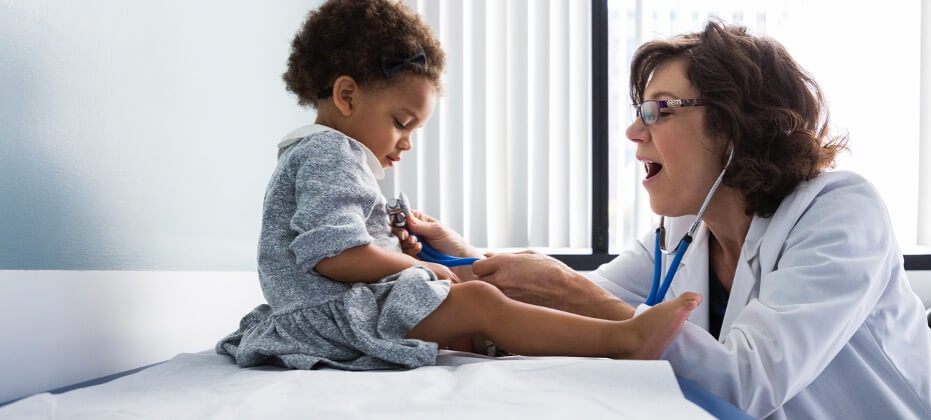 doctor examining small child on table