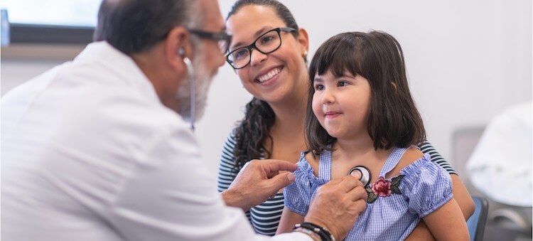 doctor examining small child with mother 