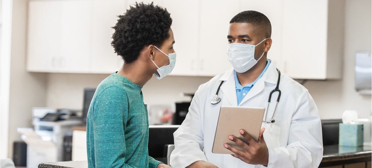 doctor holding a tablet while talking with patient