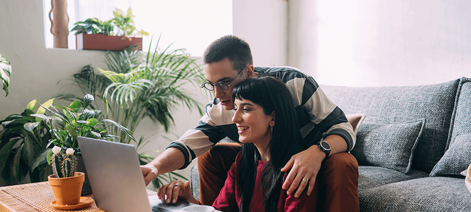 Couple looking at a computer screen in living room