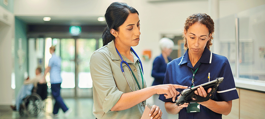 medical practitioner pointing at a tablet