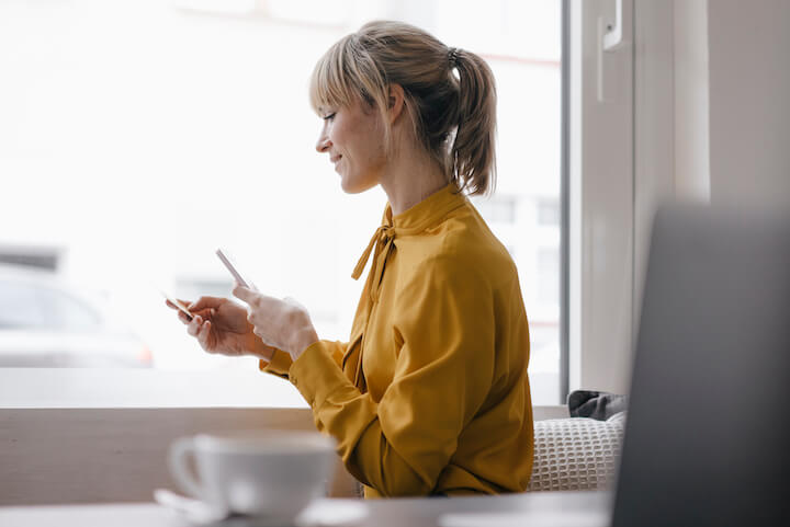 woman scanning insurance card with phone at desk