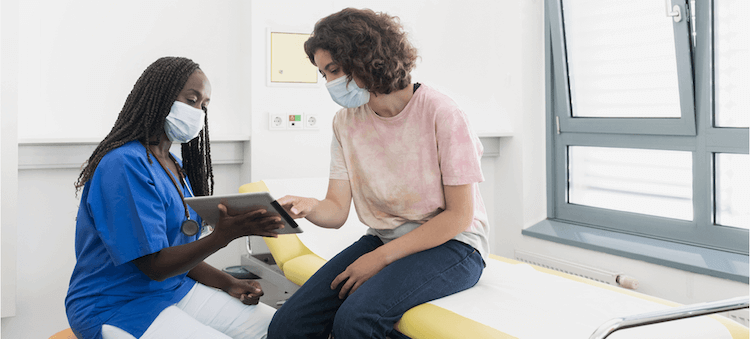 Nurse working with patient on tablet