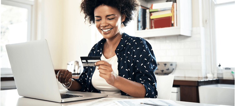 woman looking at credit card and laptop