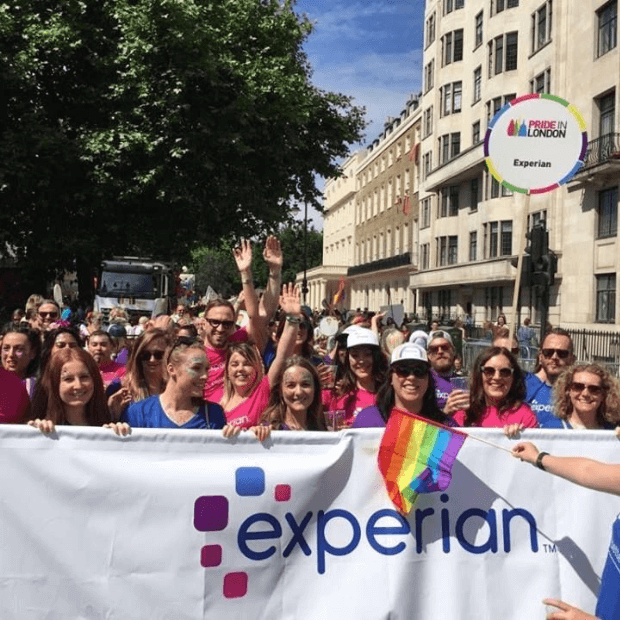 9 of 10 logos - People at London Pride behind an Experian banner